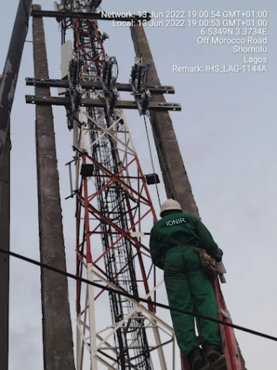 Ionir Integral engineer working on 33kV feeder cross-arms beside an IHS Towers telecom tower in Shomolu